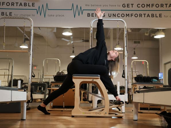 A BODYBAR Pilates instructor stretching using a Pilates equipment.