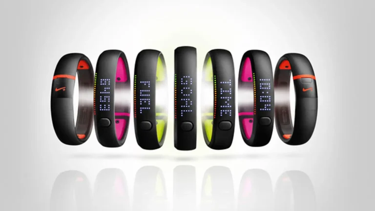 Seven black Nike fitness bands display different LED screen messages; bands are shown in a row on a light background.
