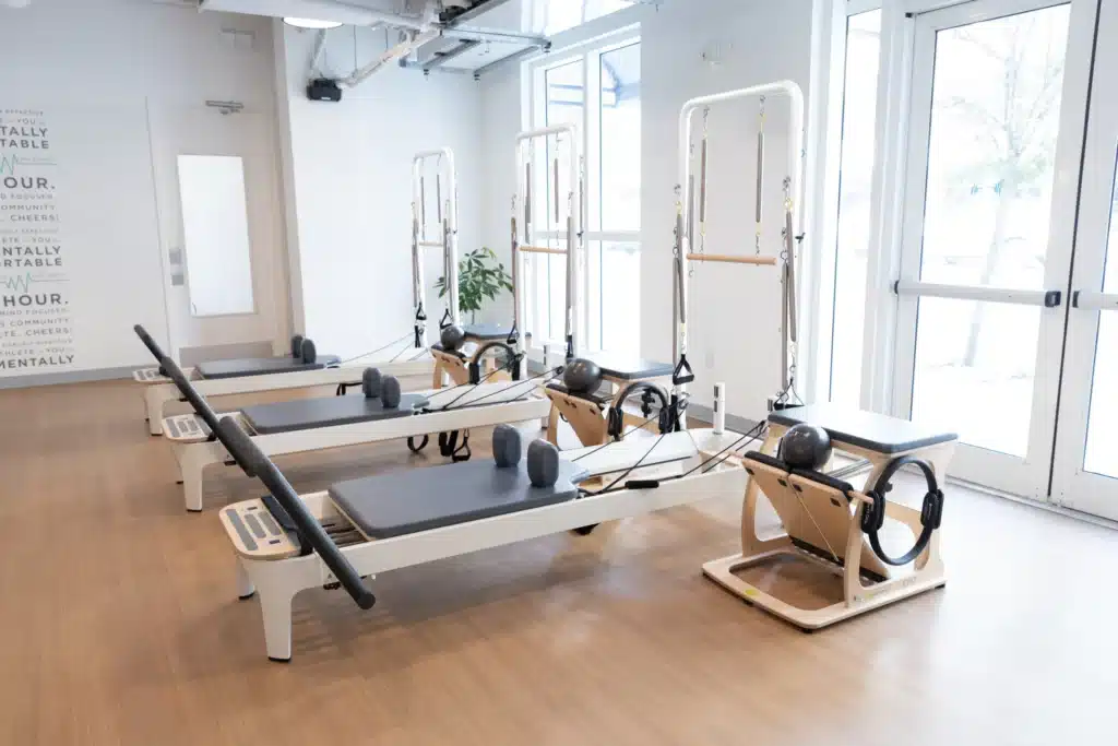Graphic of standard bodybar class equipment including reformer and chair.L abels include foot straps, springs, shoulder blocks, chair, carriage, and roll-down bar.